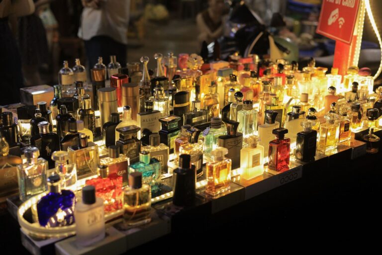A colorful display of perfume bottles lit up at a night market in Vietnam, capturing the lively atmosphere.